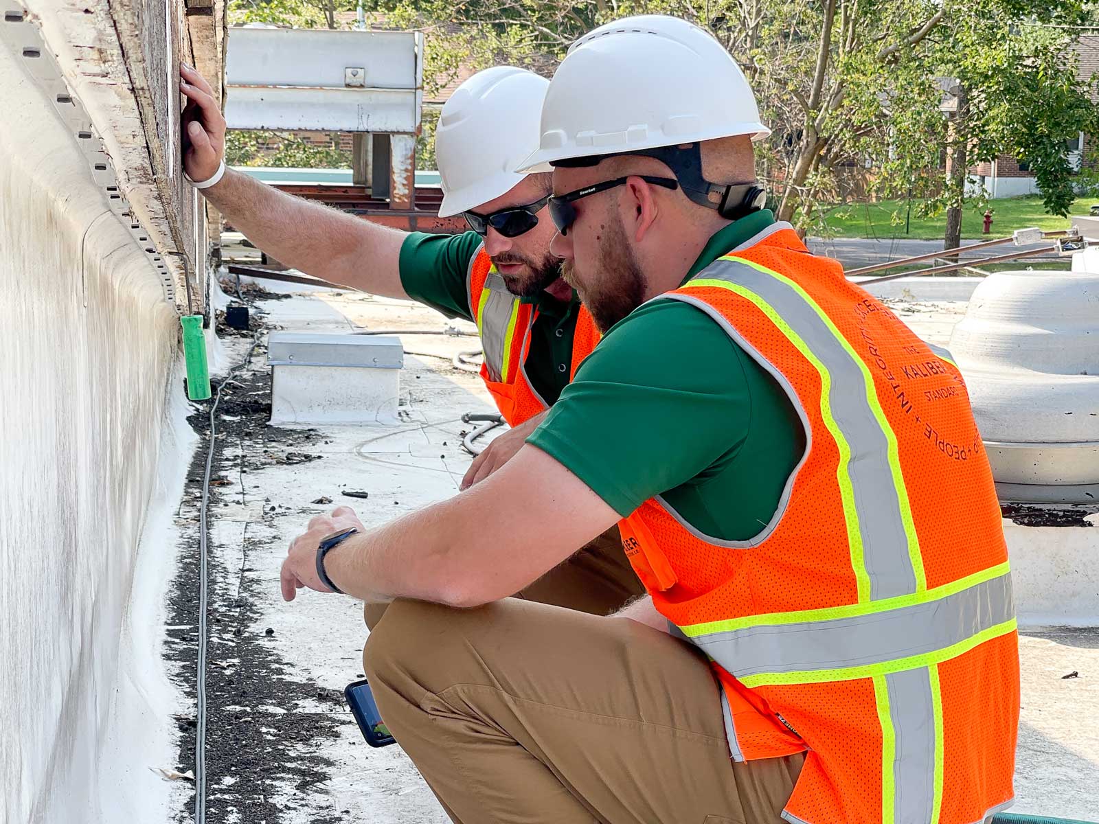 two Kaliber Contracting employees inspecting a roofs integrity