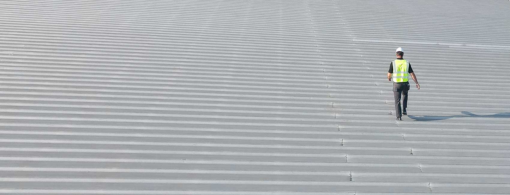 roofer walking along a industrial roof