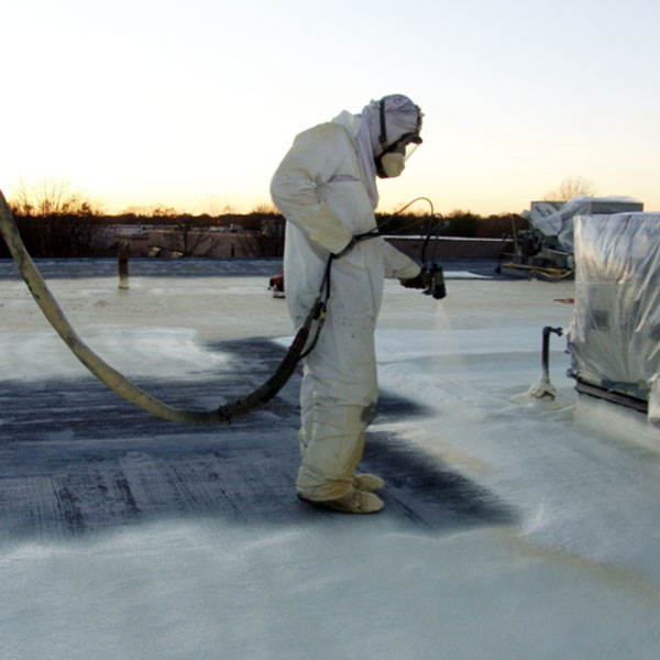 roofer spraying spf roof coating